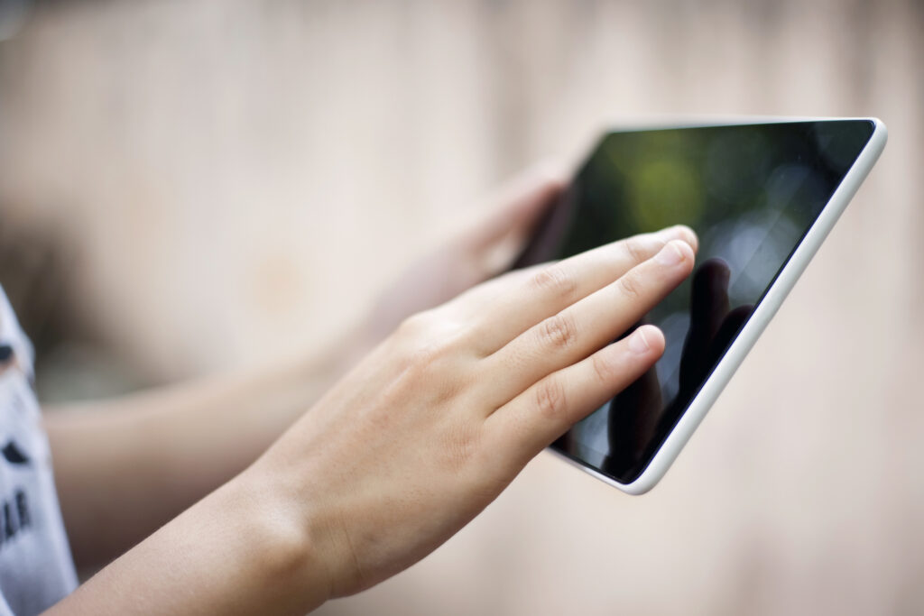 Hand holding digital tablet outdoor.