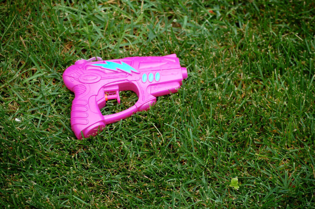 Pink water gun on the grass.