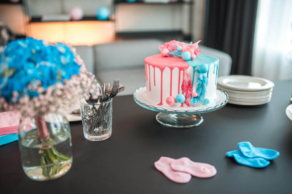 Photo of a modern surprise cake with colorful decoration for a gender reveal party.